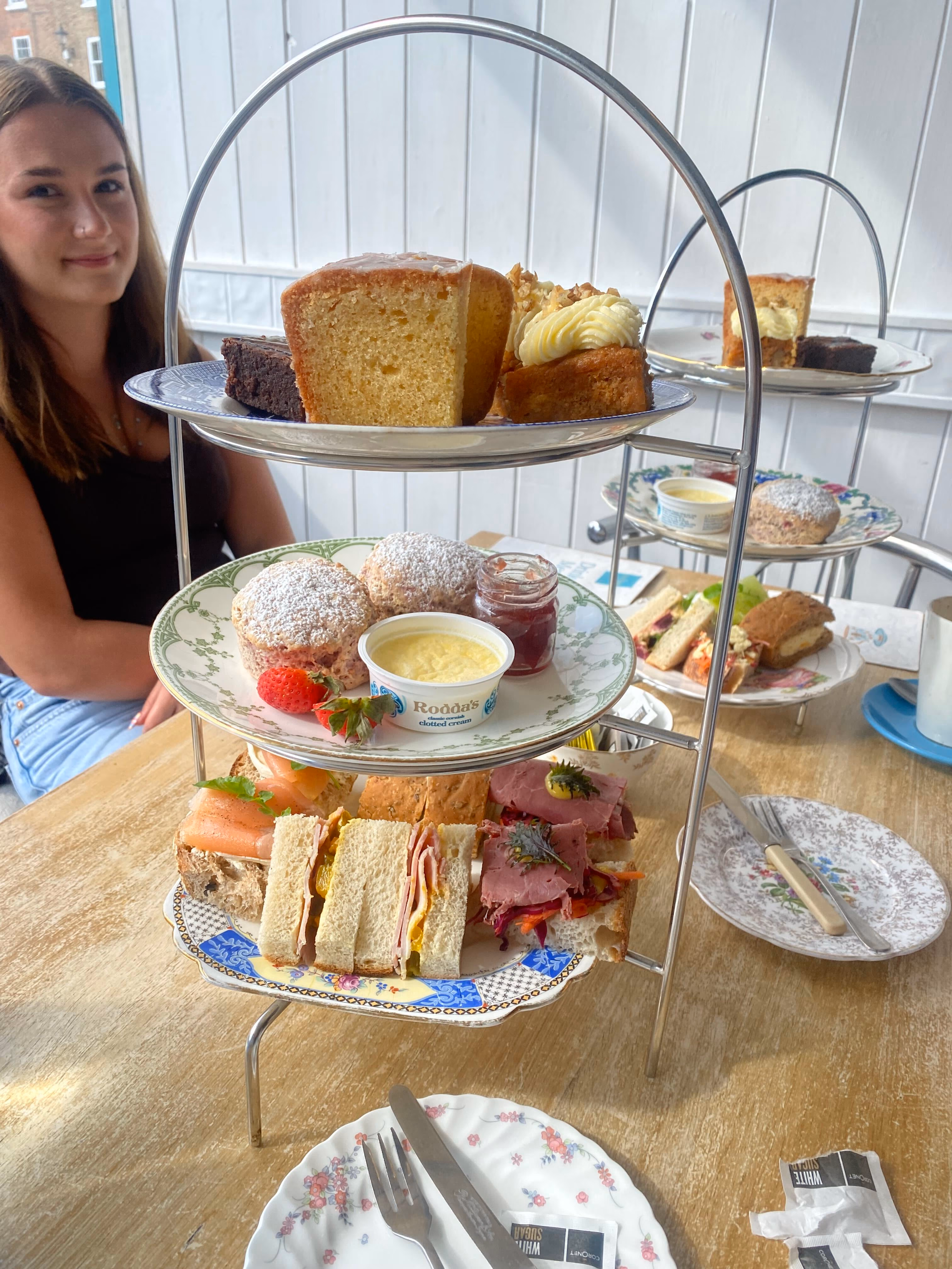 Afternoon tea at Tea Time, a three-tier stand of finger sandwiches, scones, clotted cream and homemade cakes on vintage crockery