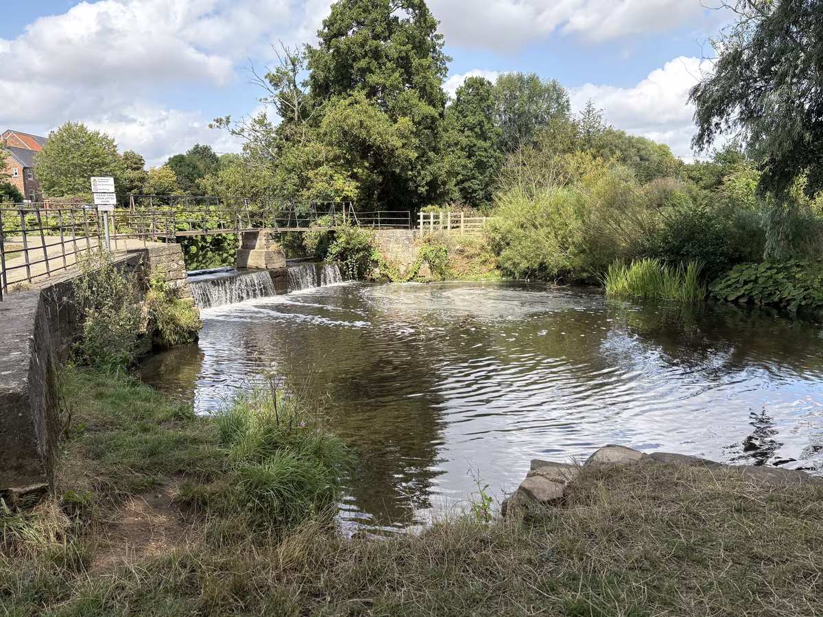 Norby Weir in full flow, the water dropping the full width of the beck