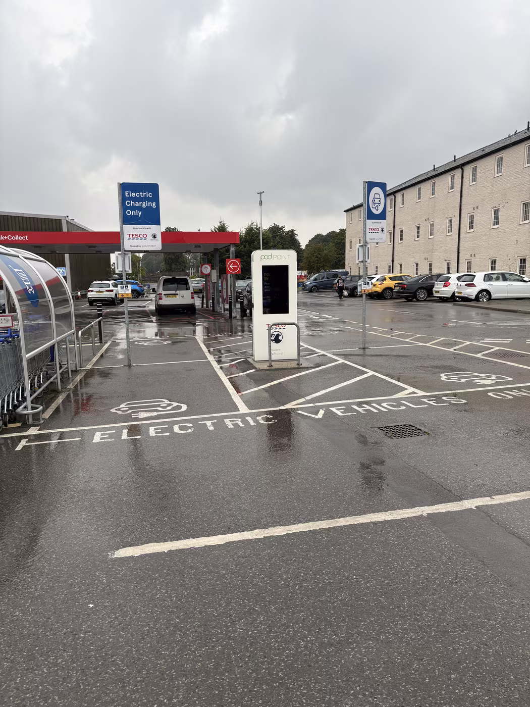 The electric charging bays in the Tesco car park in Thirsk on a wet day, with the Pod Point unit between two marked spaces