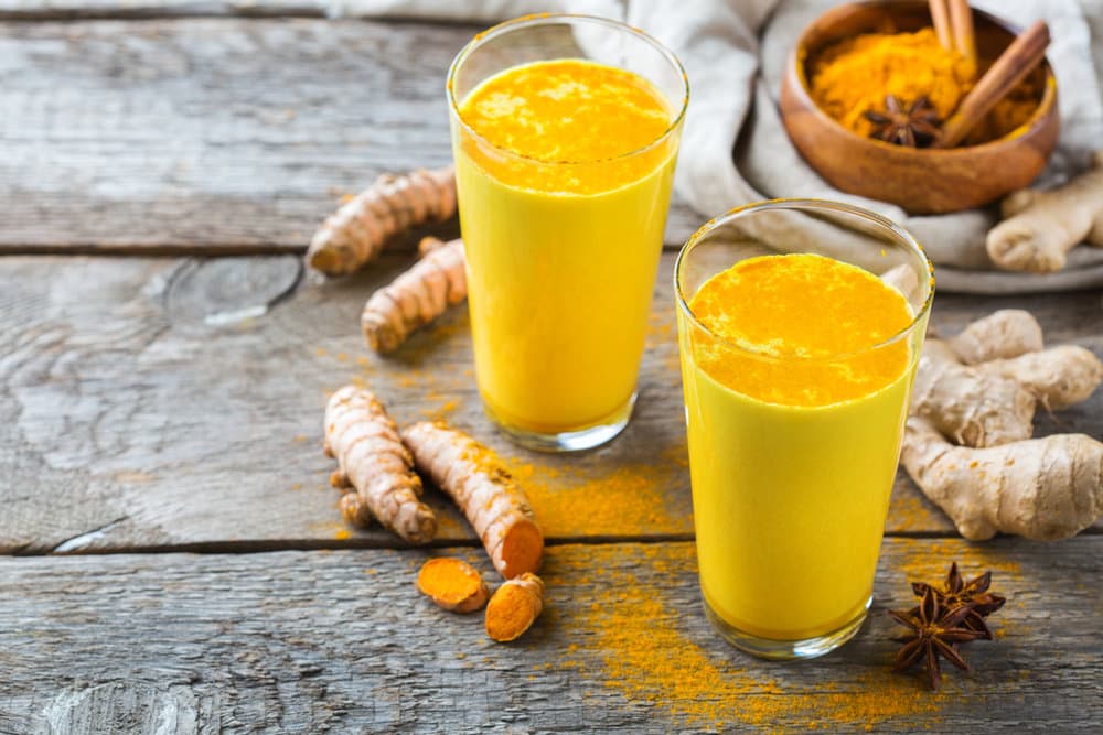 A golden turmeric latte in a mug, dusted with cinnamon