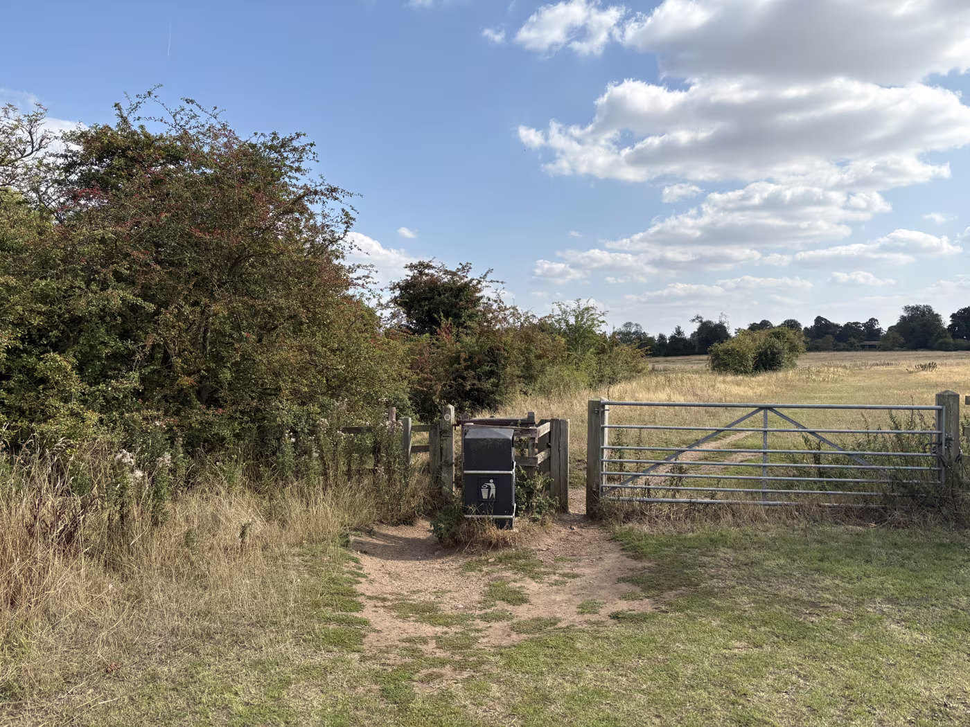 The field gate and kissing gate at the edge of Sowerby Flatts, where the path leaves the houses behind