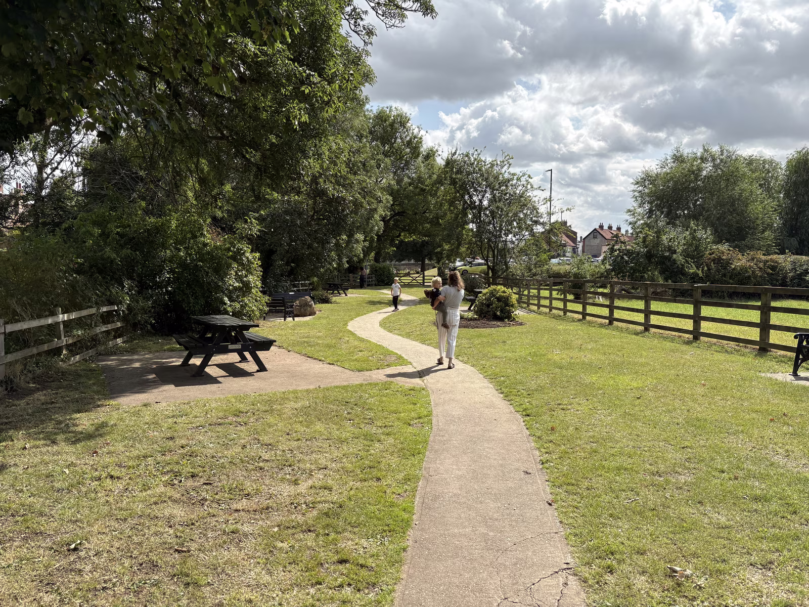 The open green at The Holmes, with picnic benches along the path
