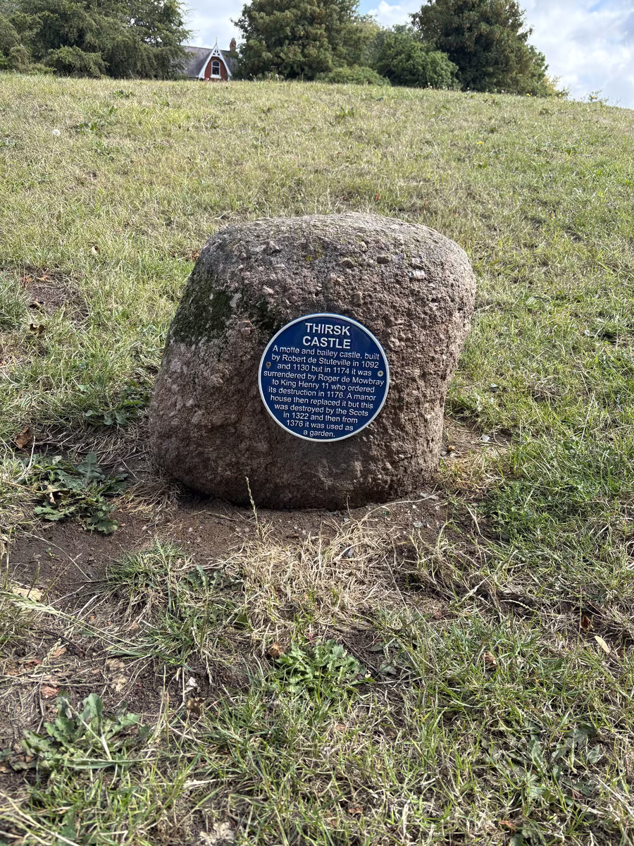 The boulder set into the grass below Castle Villa