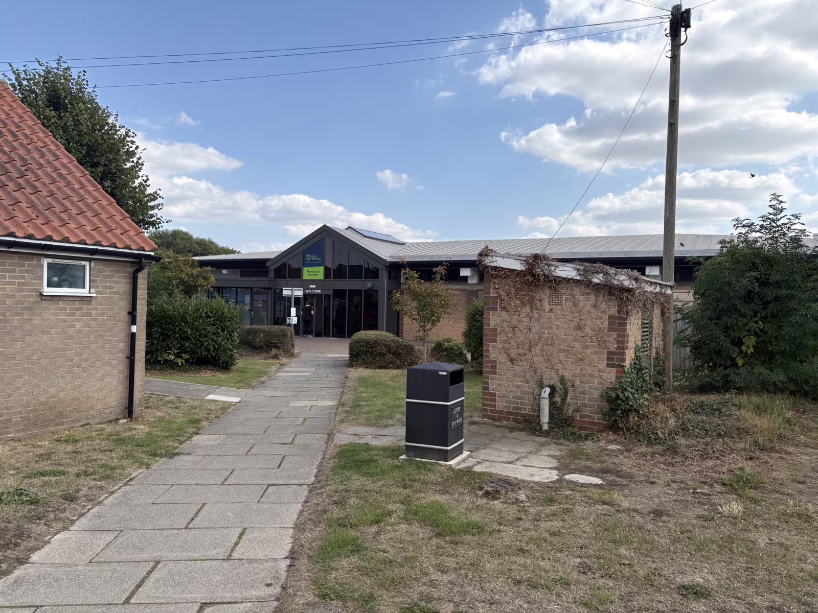 The older brick range beside the new entrance, with the path in from the car park