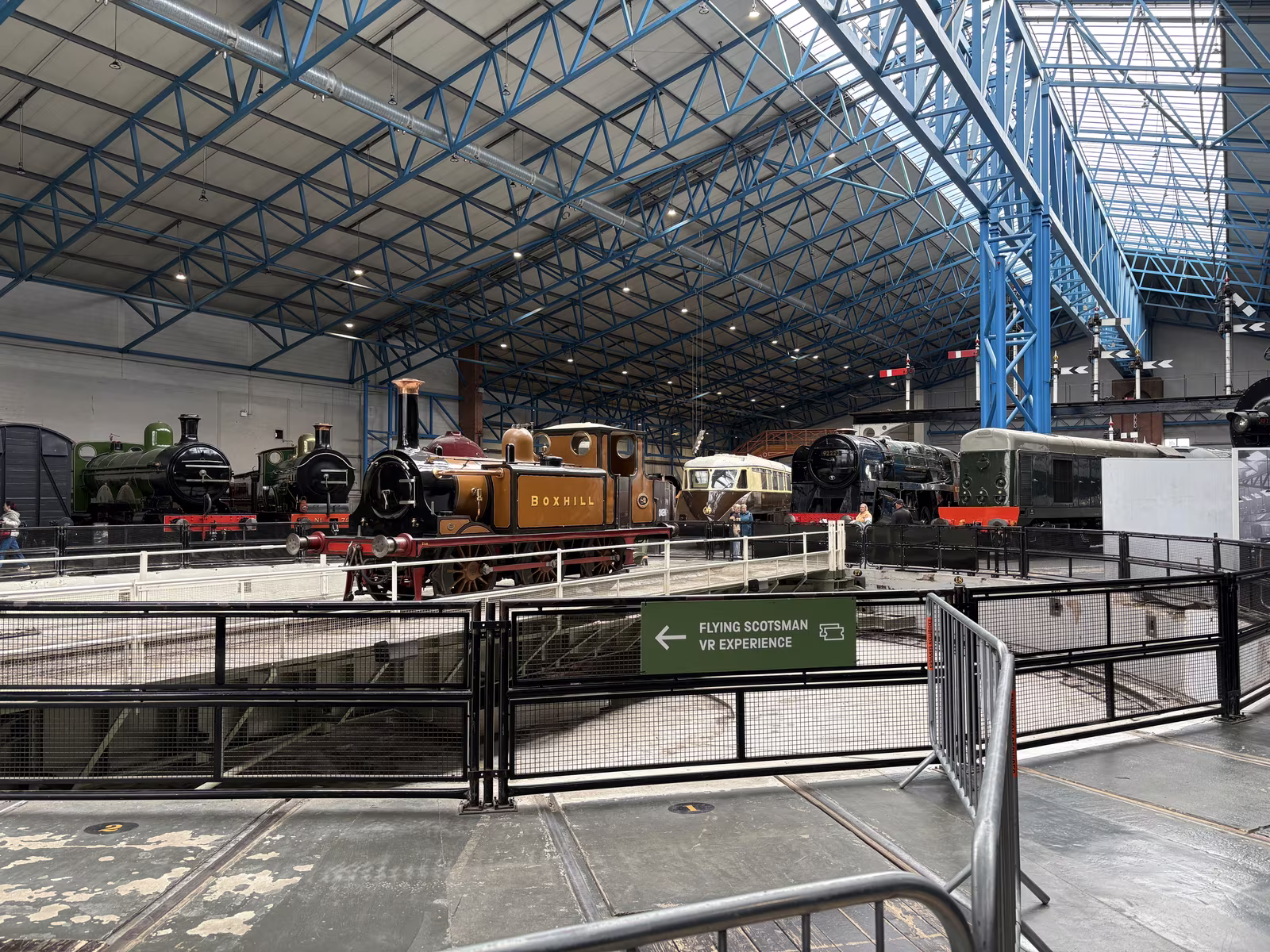 Locomotives parked nose-in around the turntable in the Great Hall, under the blue steel roof
