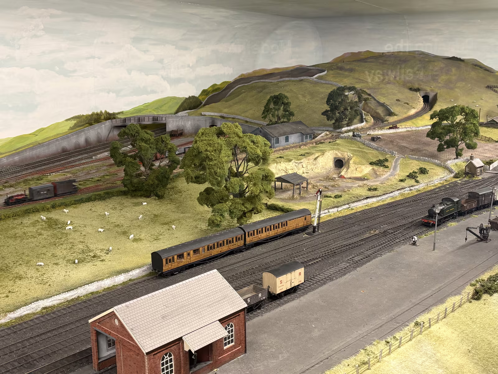 The model railway, with a train running past a hillside and sidings