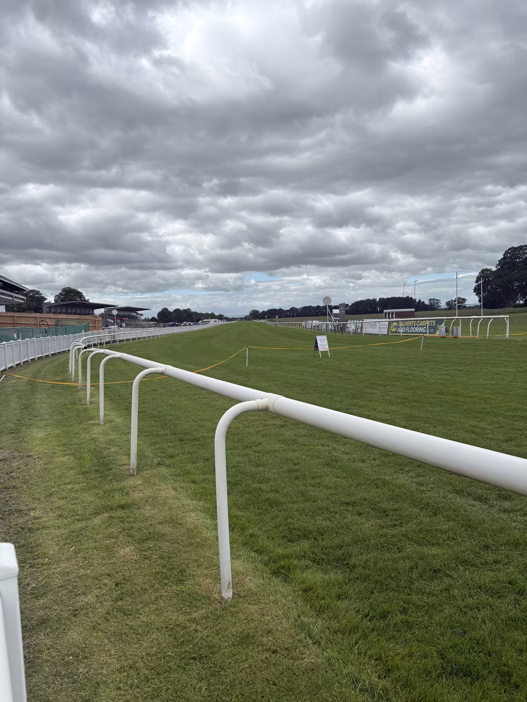 The running rail and the open track at Thirsk Racecourse, looking away from the stands on a quiet morning